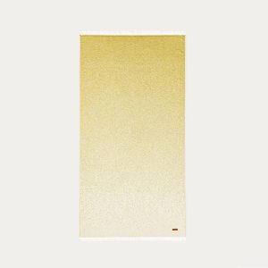 Toalla playa Briciní Monterosso. Diseño liso con degradé al tono de la toalla. 100% algodón remate flecos blancos. Color mostaza